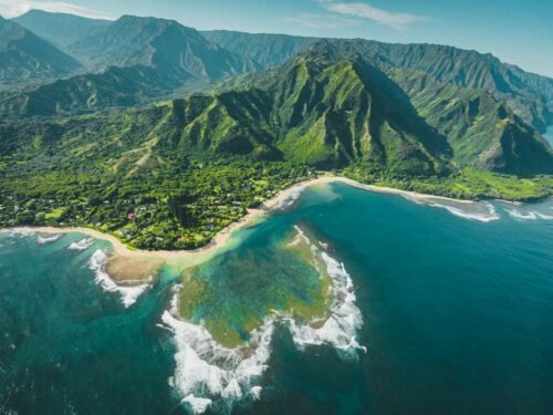aerial view of green and brown mountains and lake