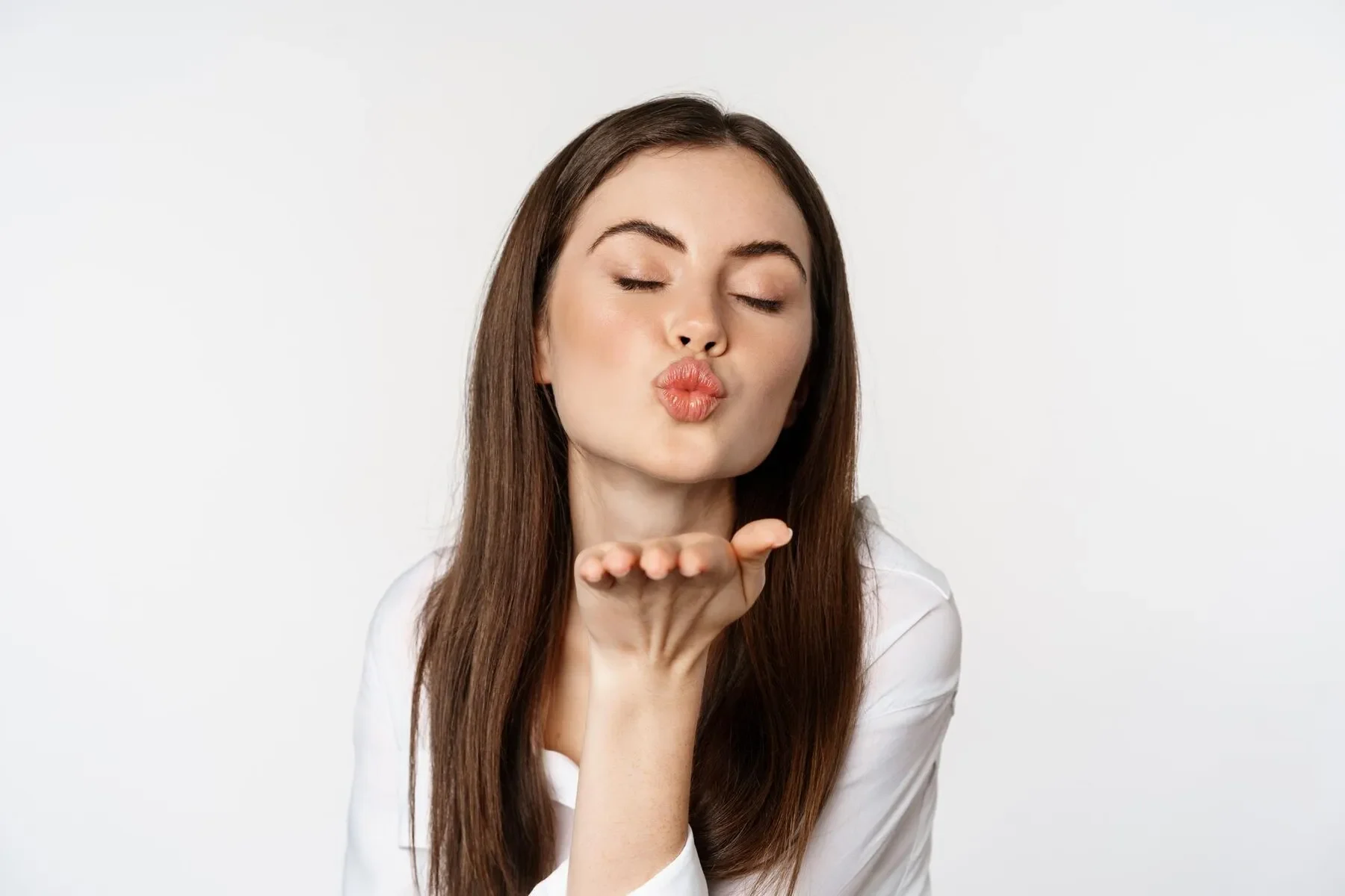 Feminine woman sending air kiss camera