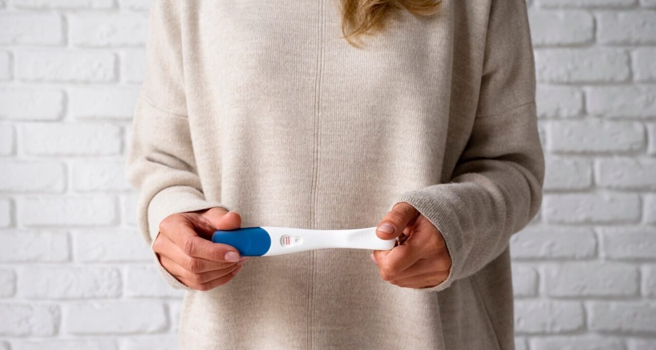 Front view woman holding positive pregnancy test