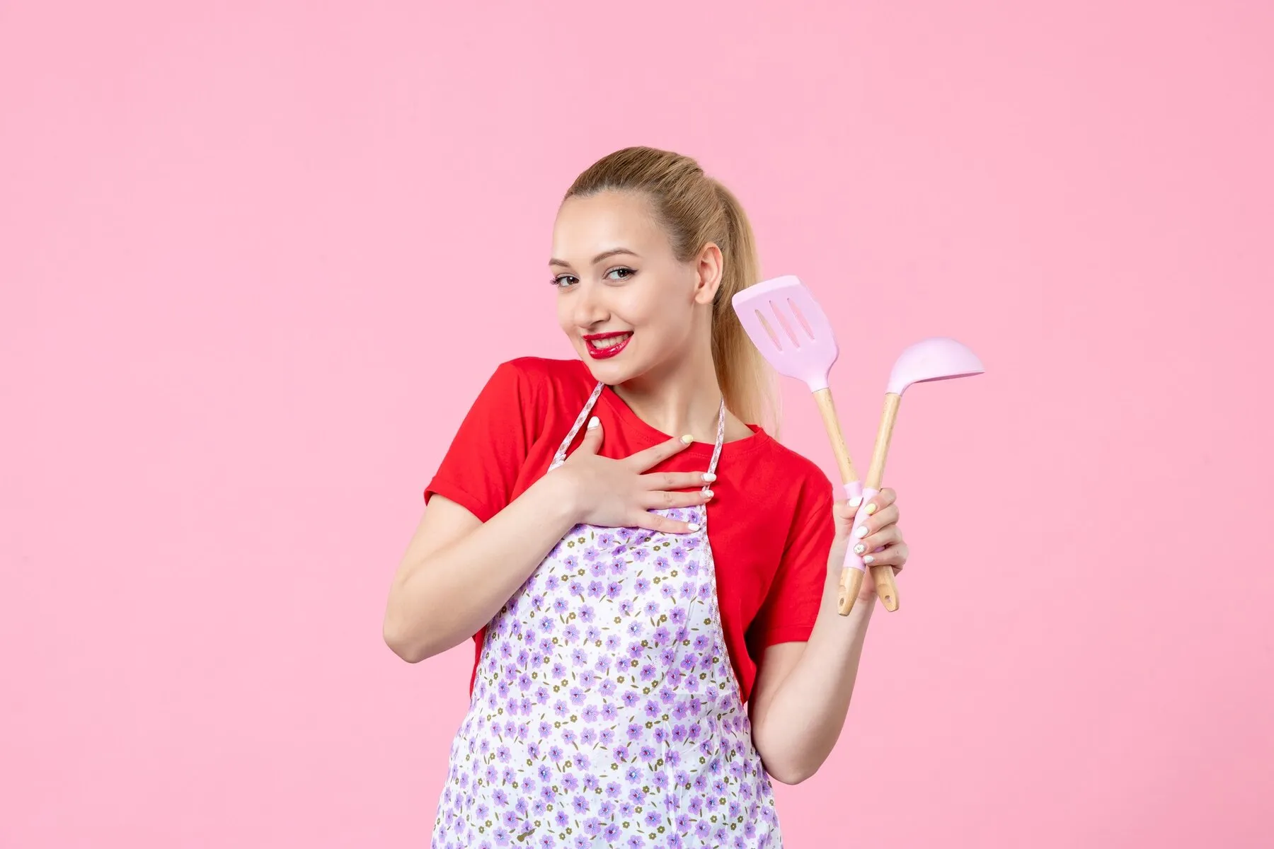 Front view young housewife posing with cutlery her hands