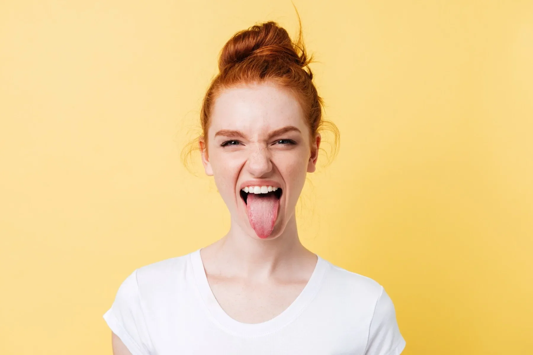 Funny ginger woman showing tongue looking