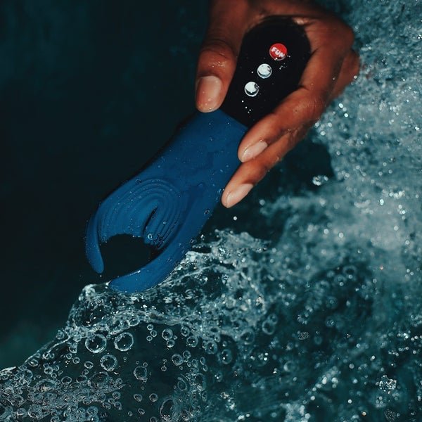 Modelis, laikantis šlapią žalsvai mėlyną vibruojančią glostytoją