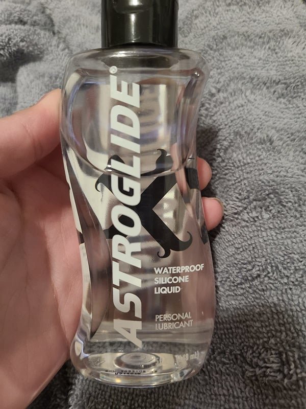 Apžvalgininkas laiko Astroglide lubrikanto buteliuką