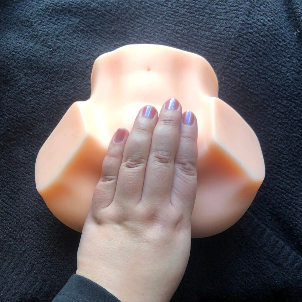 Hand cupping the vulva on a masturbator