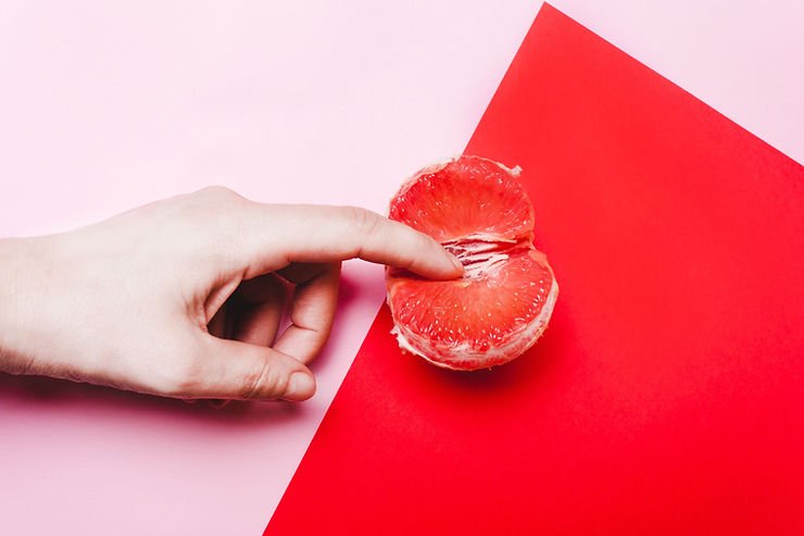 A finger fingers an orange