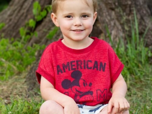 a little boy that is sitting in the grass