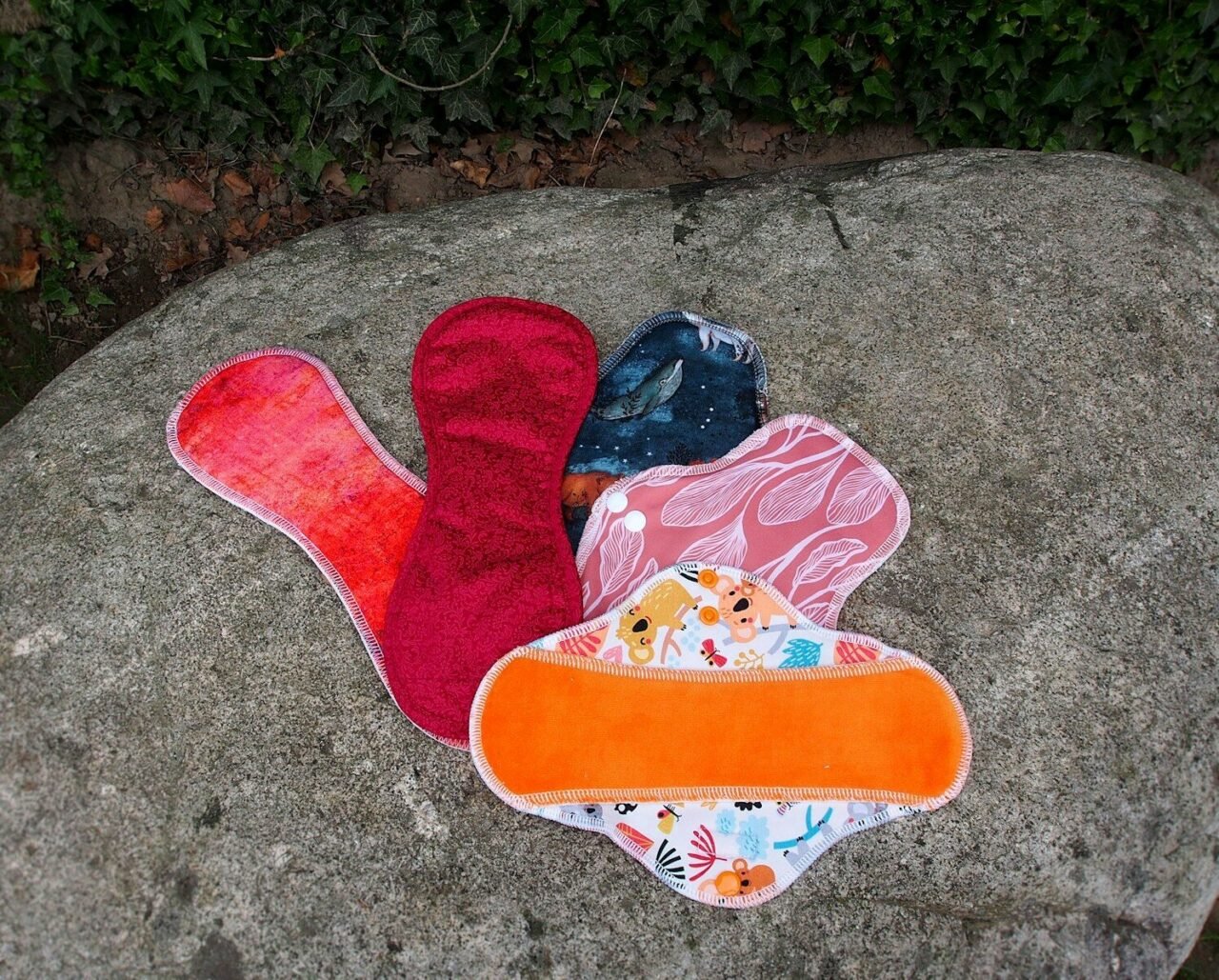 a pair of oven mitts sitting on top of a rock