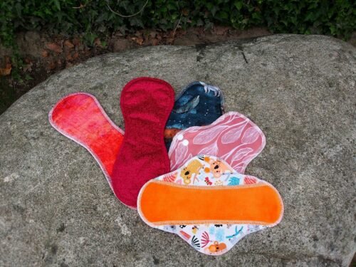 a pair of oven mitts sitting on top of a rock