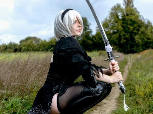 a woman kneeling down with a sword in her hand