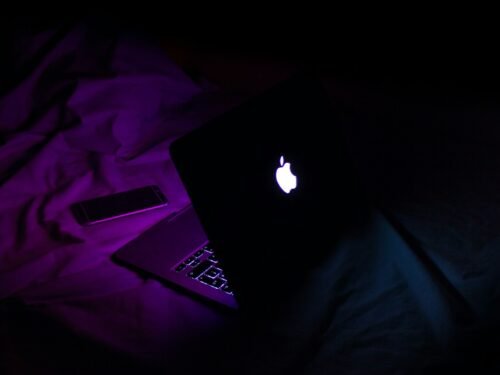 silver MacBook beside smartphone