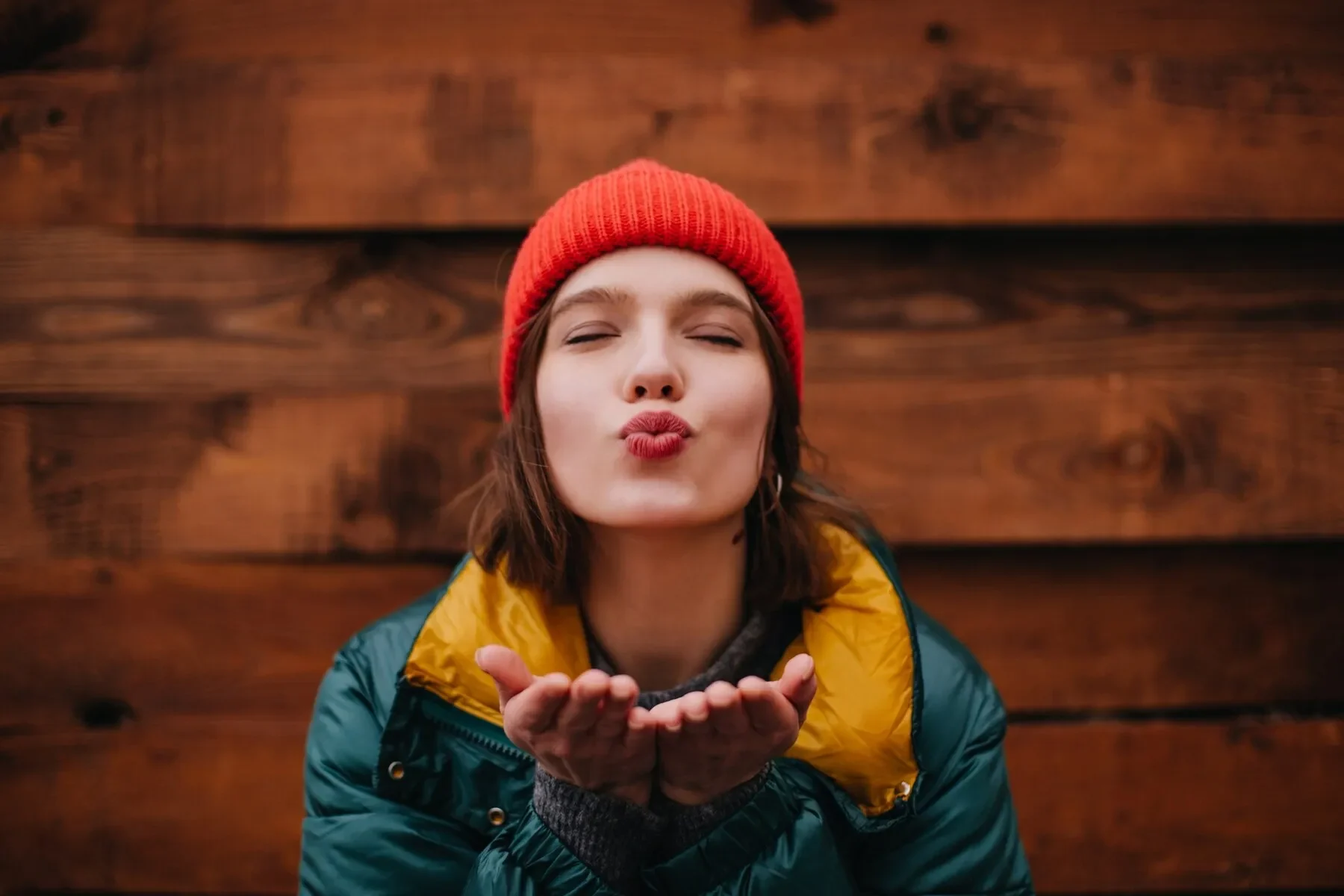 Lady red hat is sending air kiss with her eyes closed