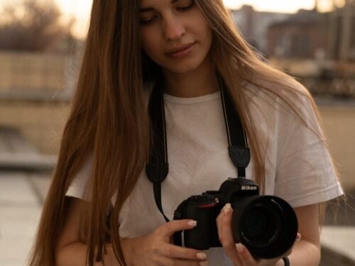 a woman with long hair holding a camera