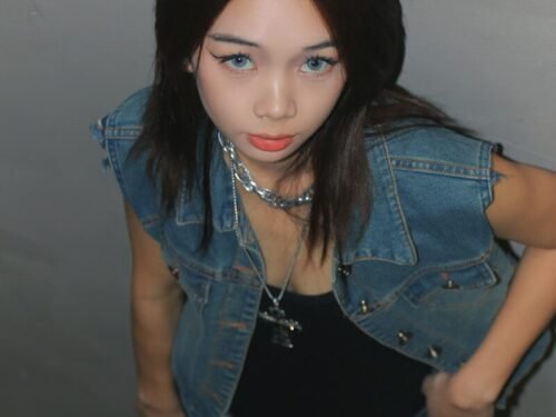 a woman in a black dress and jean jacket