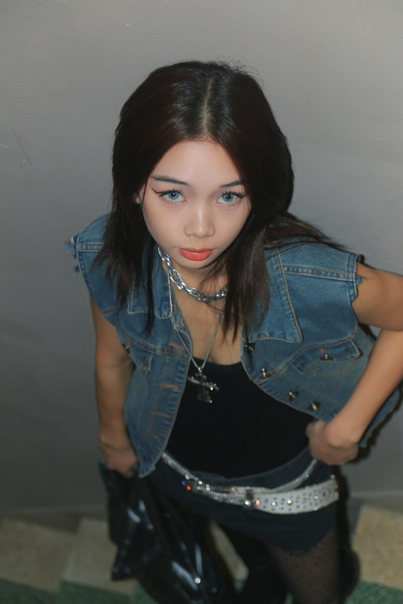 a woman in a black dress and jean jacket