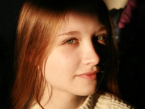 a woman with red hair and a turtle neck sweater