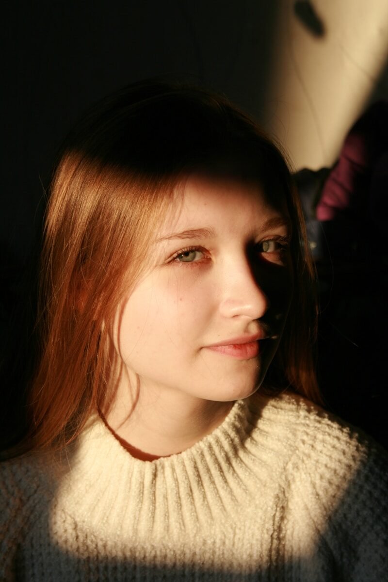 a woman with red hair and a turtle neck sweater