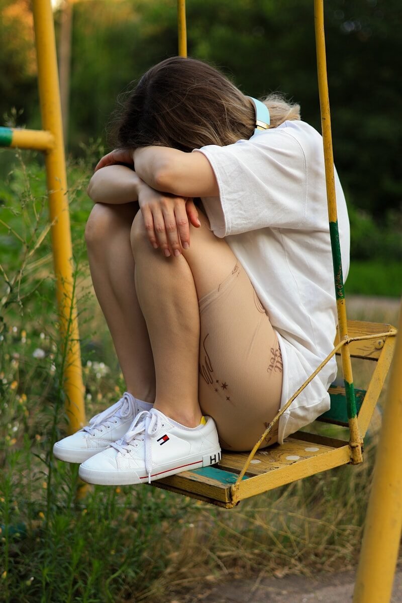 a woman sitting on a swing with her legs crossed