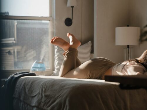 a woman laying on a bed in a bedroom