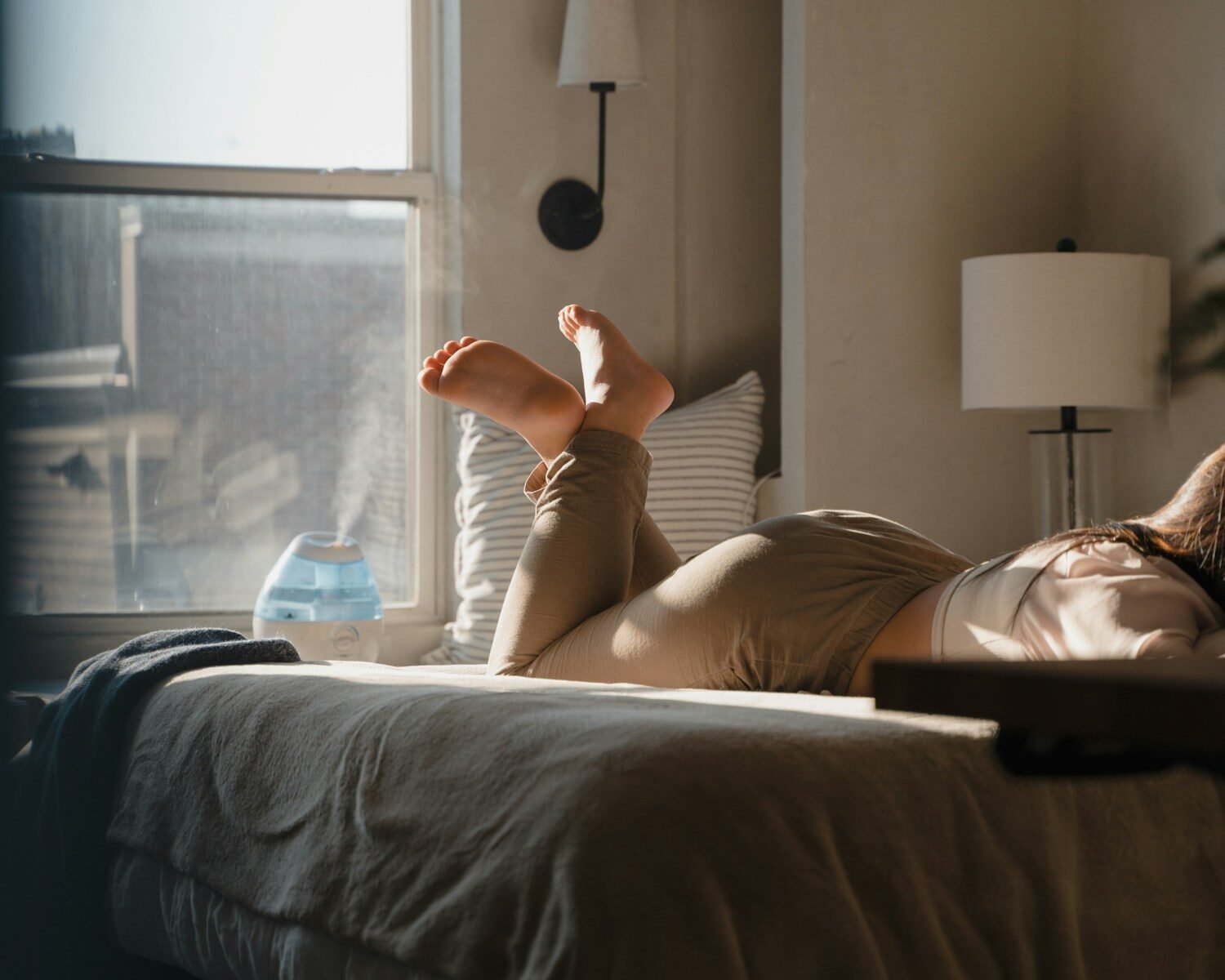a woman laying on a bed in a bedroom