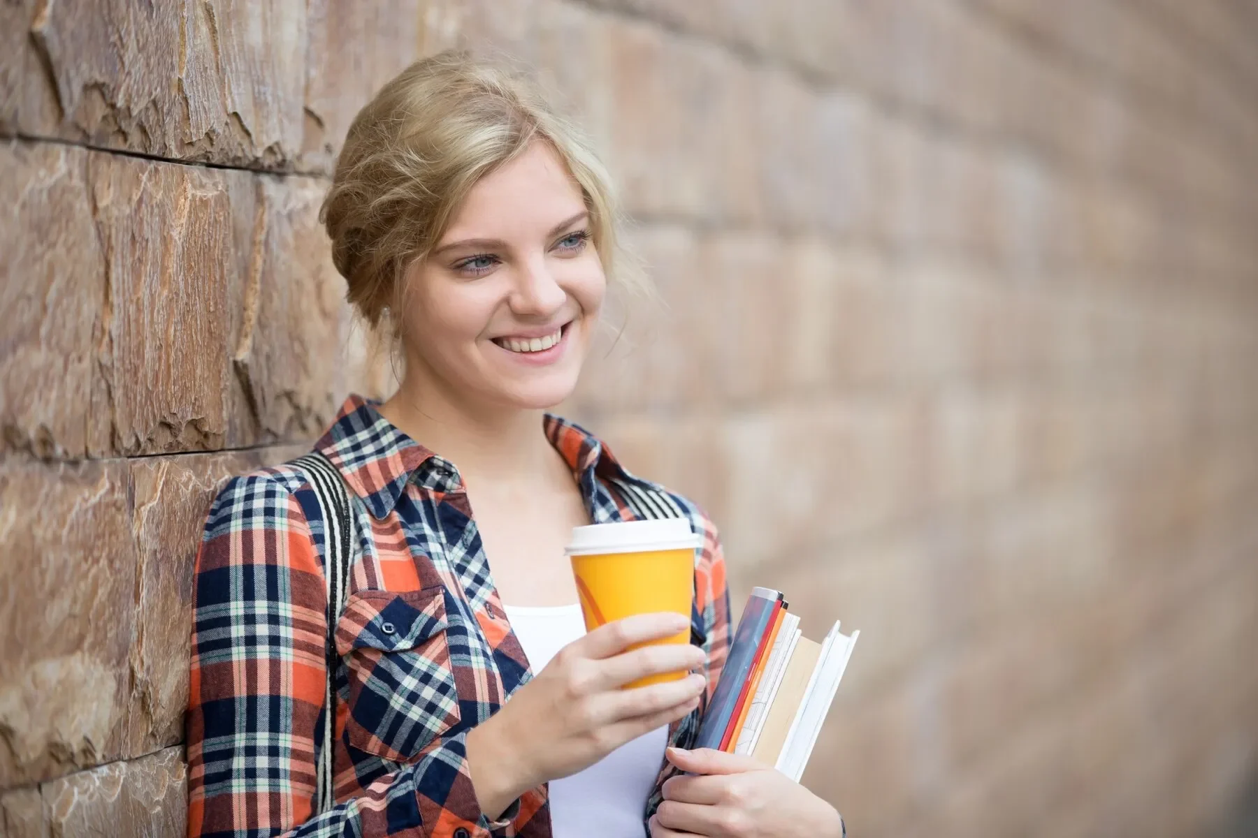 Portrait student girl against brick wall
