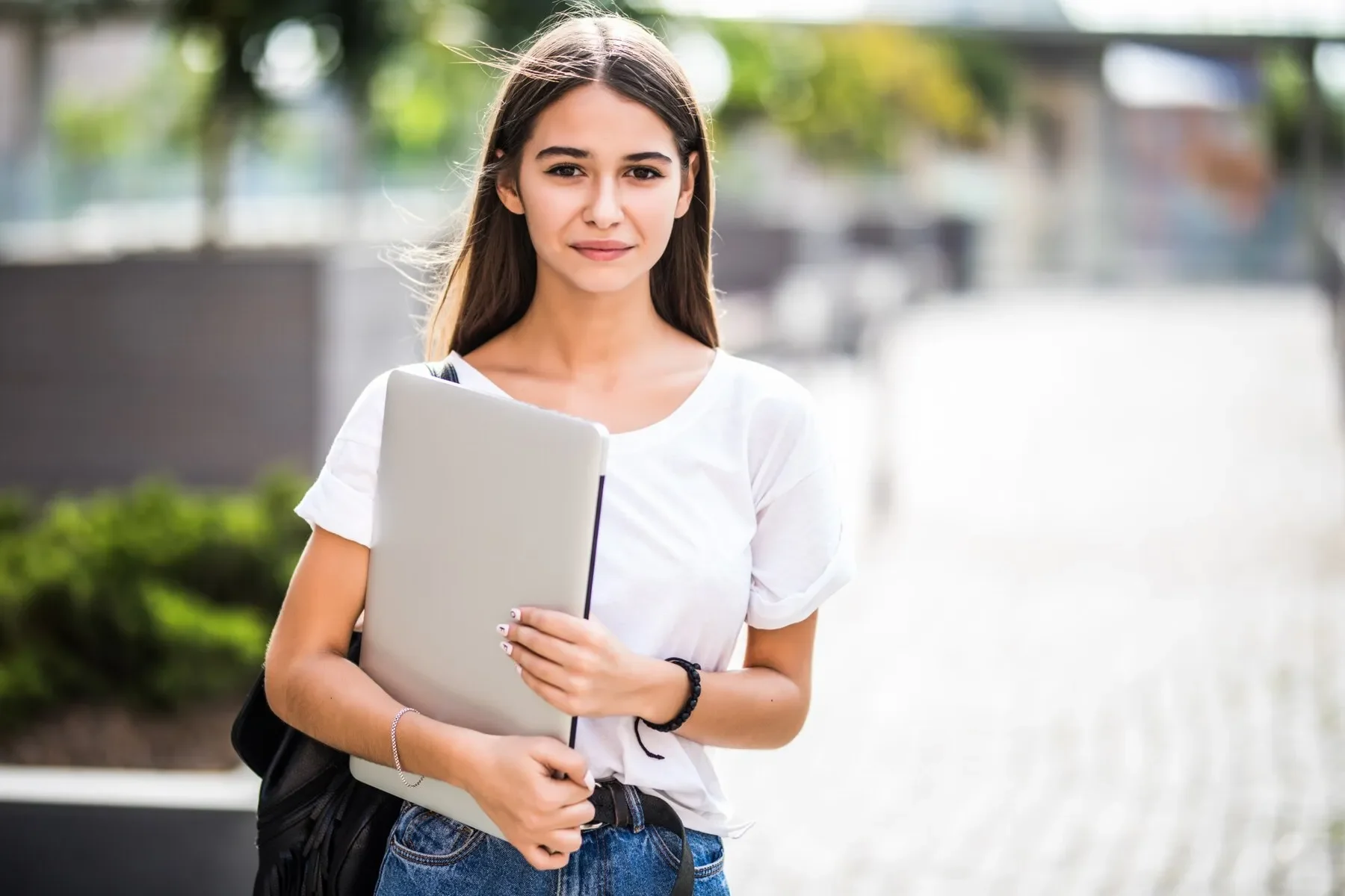 Portrait young happy blogger with modern laptop outdoors