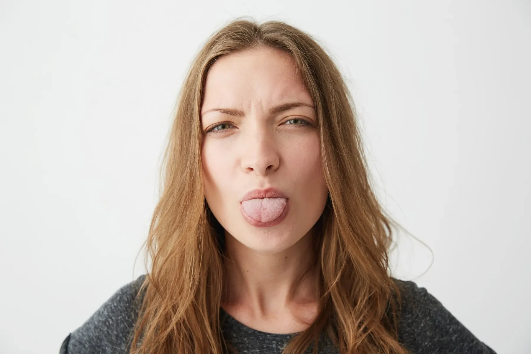 Portrait young pretty funny girl showing tongue