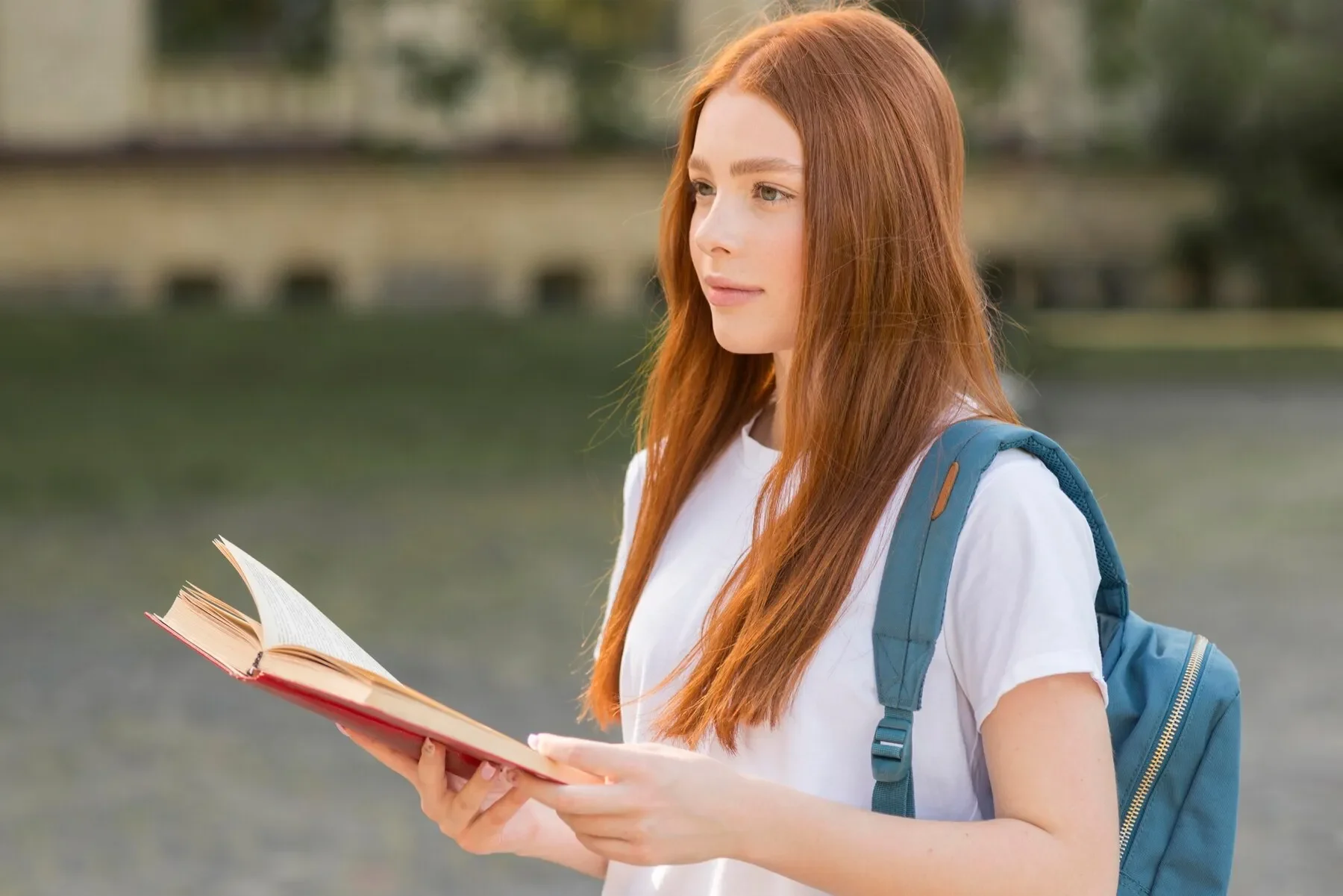 Pretty teenager walking through university campus