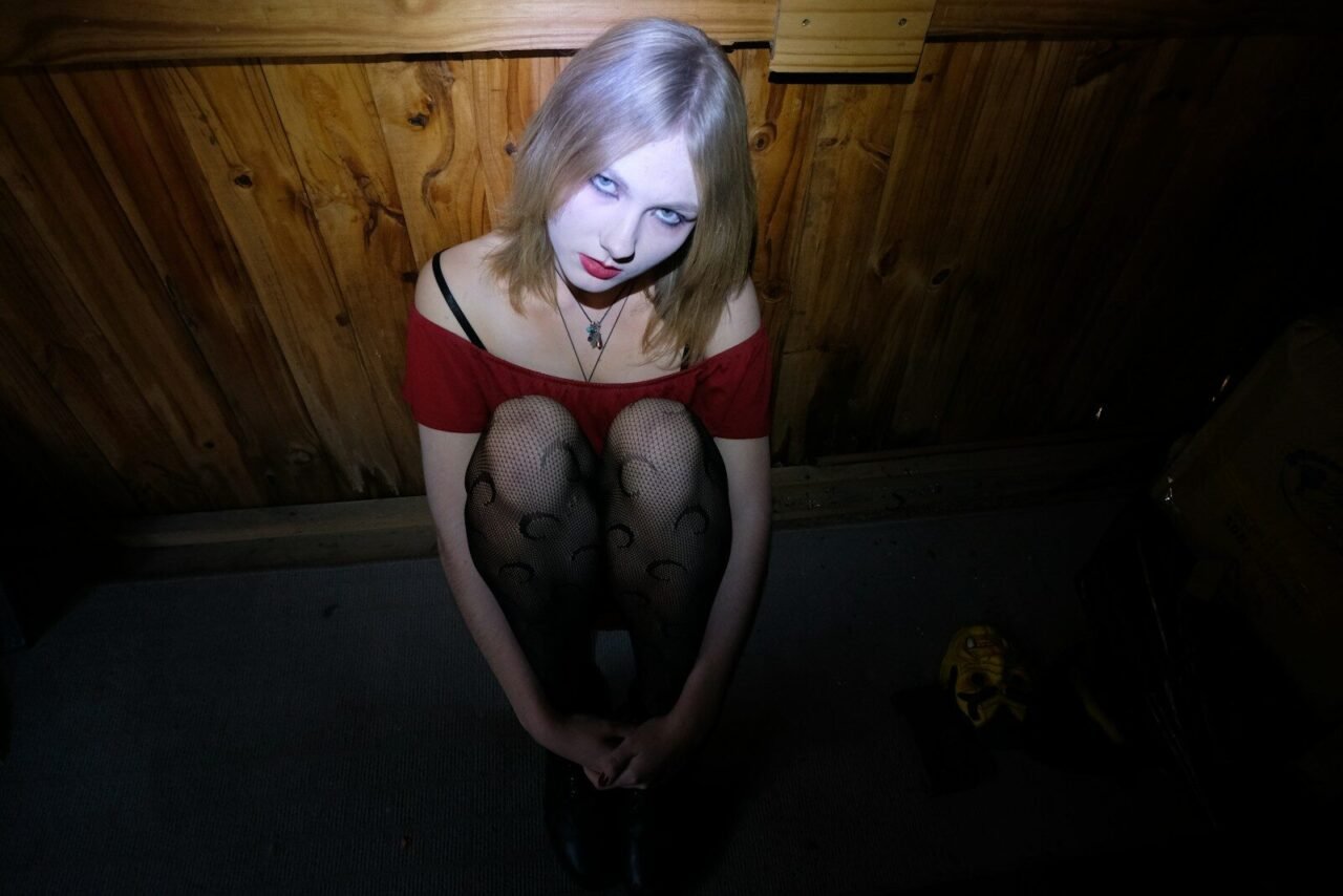 A woman in a red top is sitting on the floor