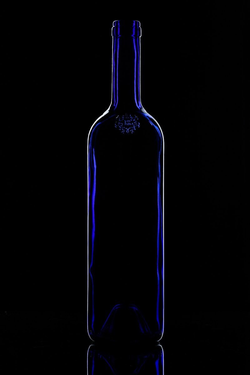 a blue glass bottle sitting on top of a table