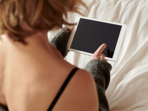 woman in black brassiere holding white ipad