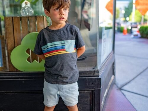 a boy standing in front of a glass door