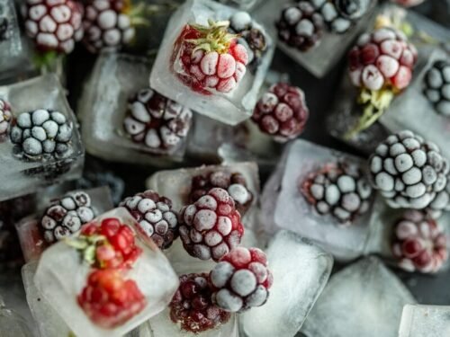 red and white round fruits on clear glass container