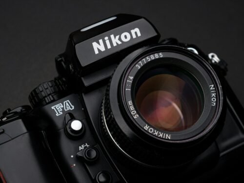 black nikon dslr camera on white surface