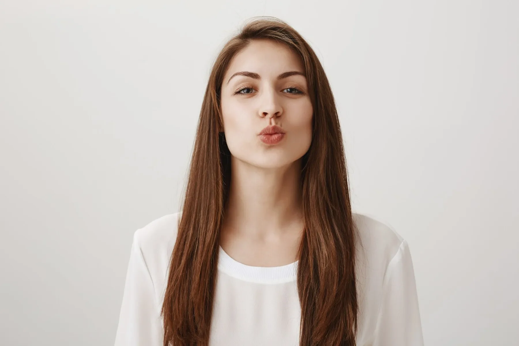 Smiling cute girl folding lips leaning kiss