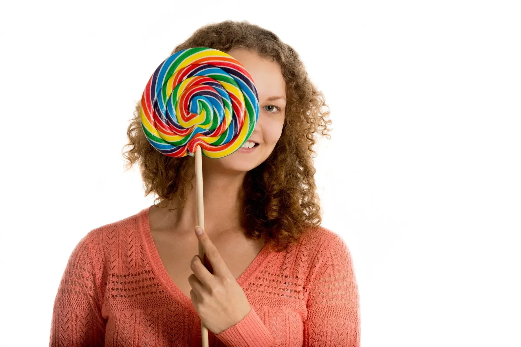 Smiling young woman showing lollipop