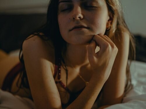 a woman laying on a bed with her eyes closed