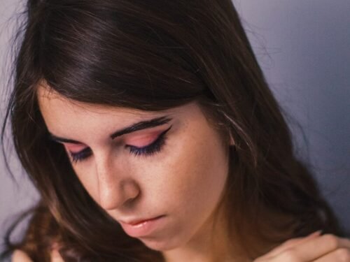 a woman is holding her arm around her neck