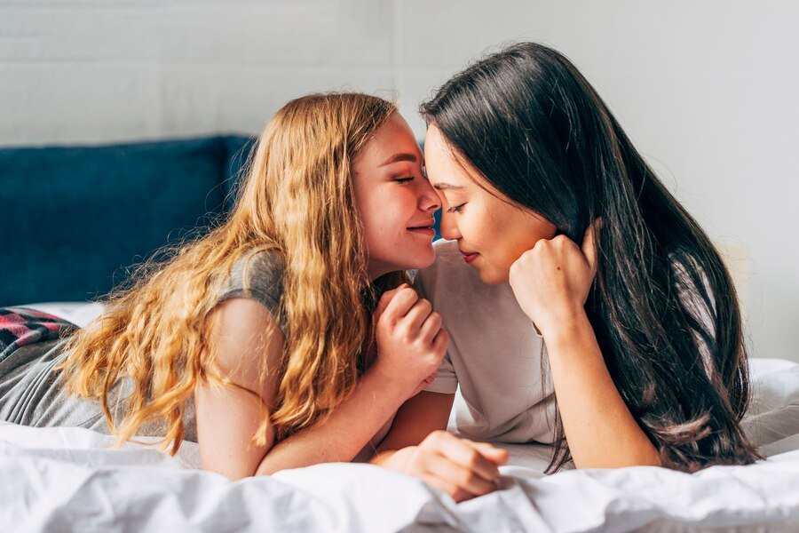 Tender lesbian couple lying bed