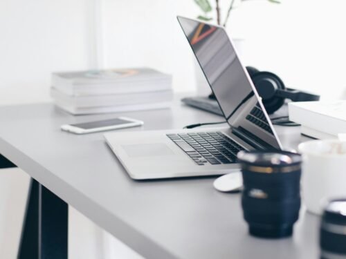 silver MacBook Pro on white table