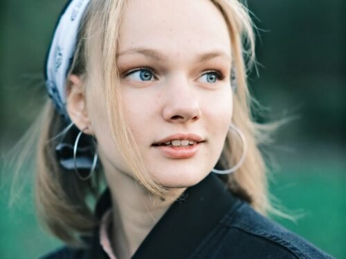 a young woman with blue eyes wearing a black jacket