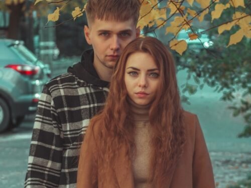 a man and a woman standing under a tree