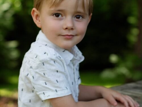 A young boy leaning on a picnic table