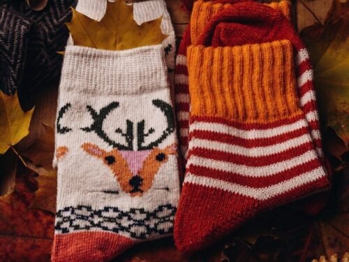 a pair of knitted socks sitting on top of a wooden table