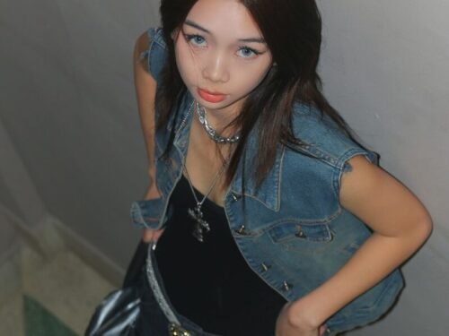 a woman in a black dress and jean jacket