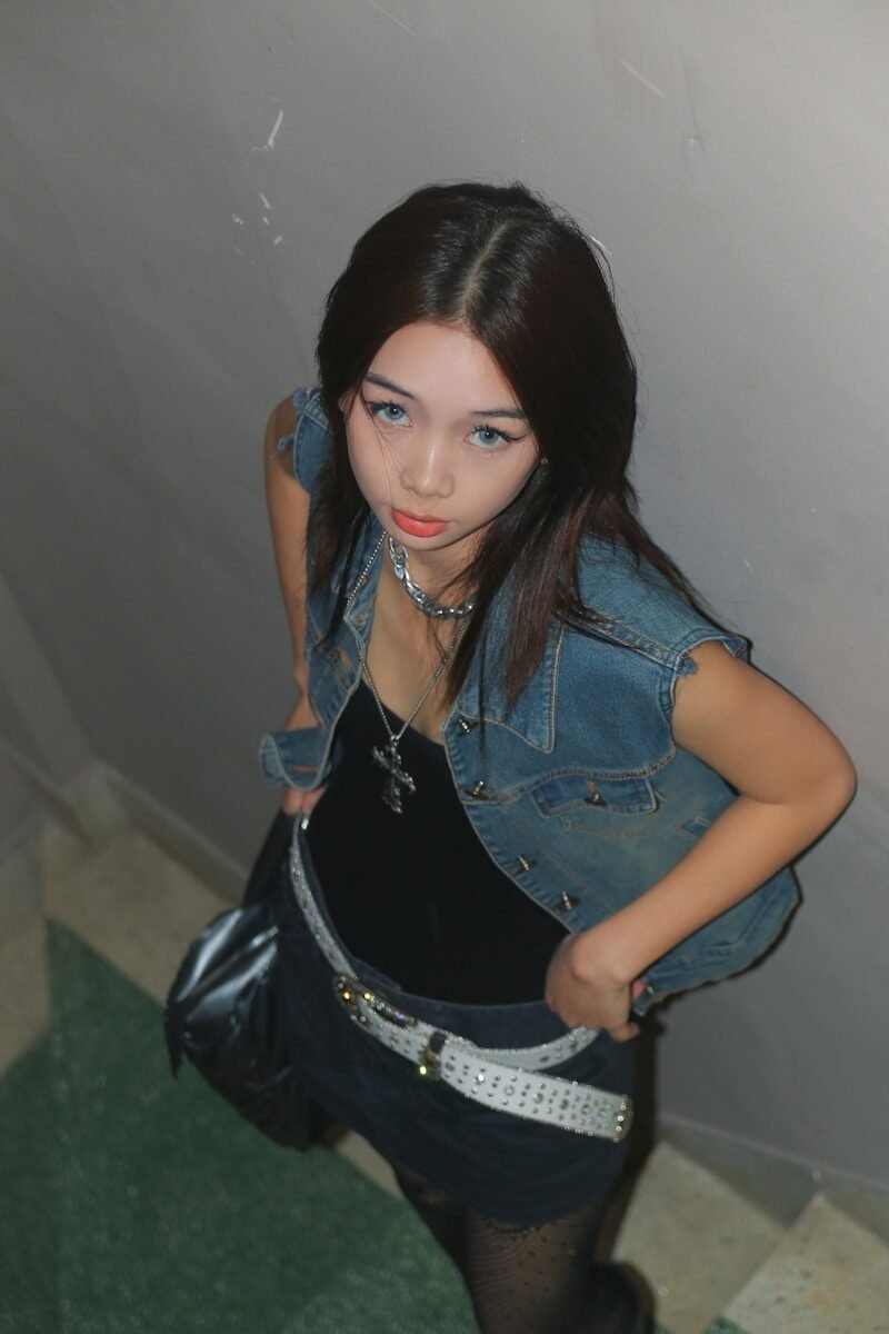 a woman in a black dress and jean jacket
