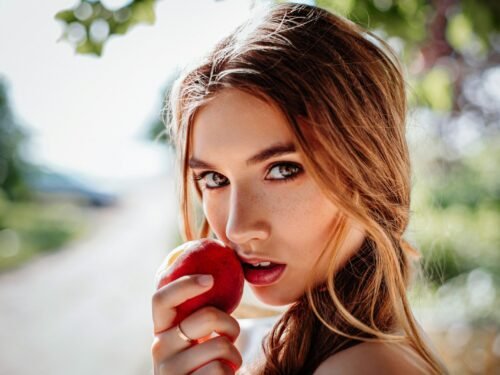 woman holding red apple fruit