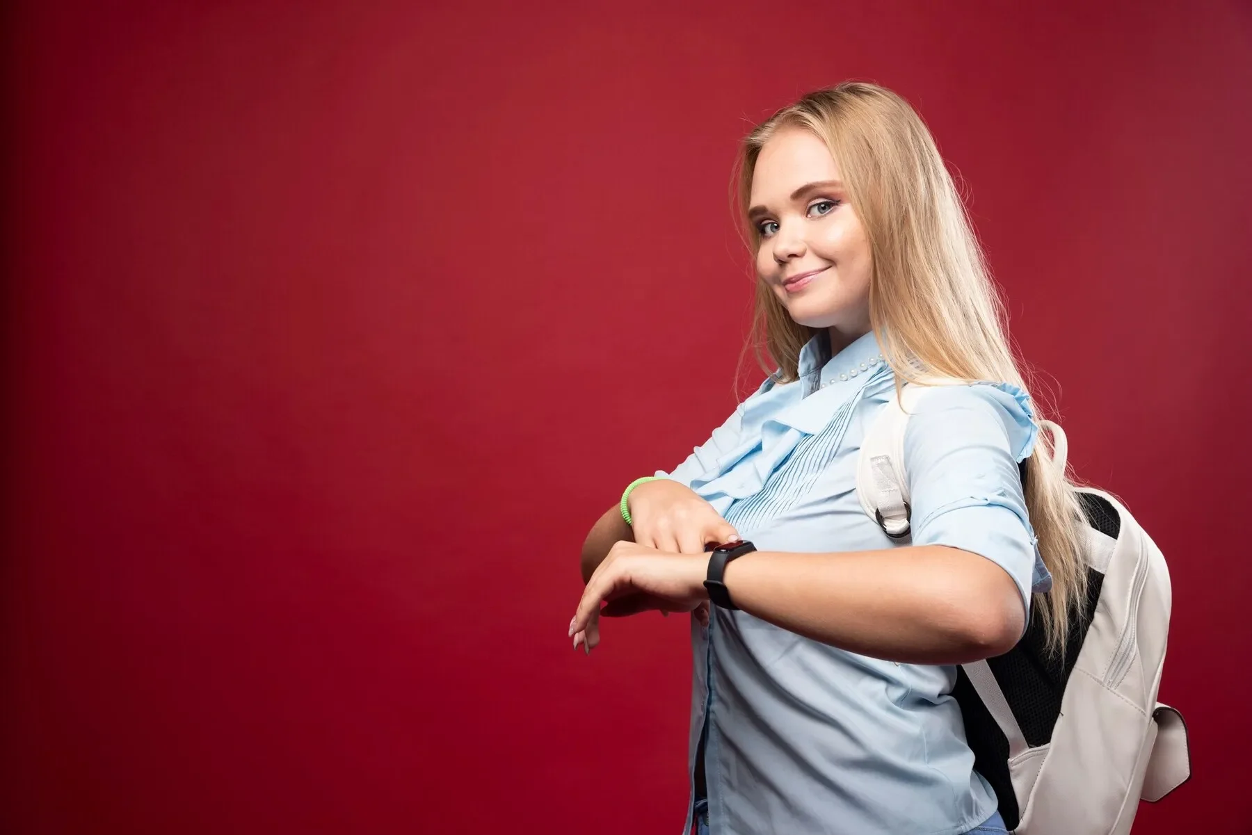 Young blonde student woman goes back school checks time her watch